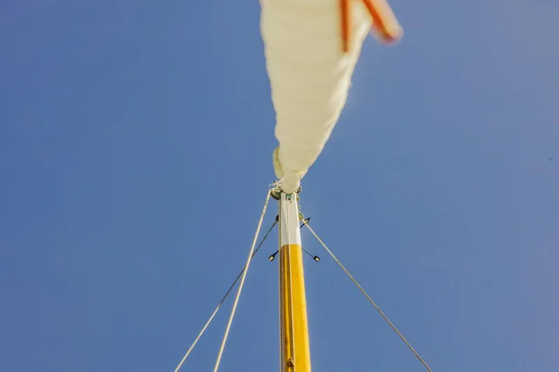 Slide: The Image of Sailboat mast and sail against clear blue sky, Lapworth 40, 1961 model. - 39