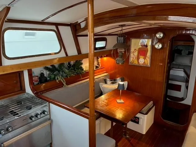 Slide: The Image of Interior of a 1961 Lapworth 40 sailboat with wooden dining area and kitchen. - 4