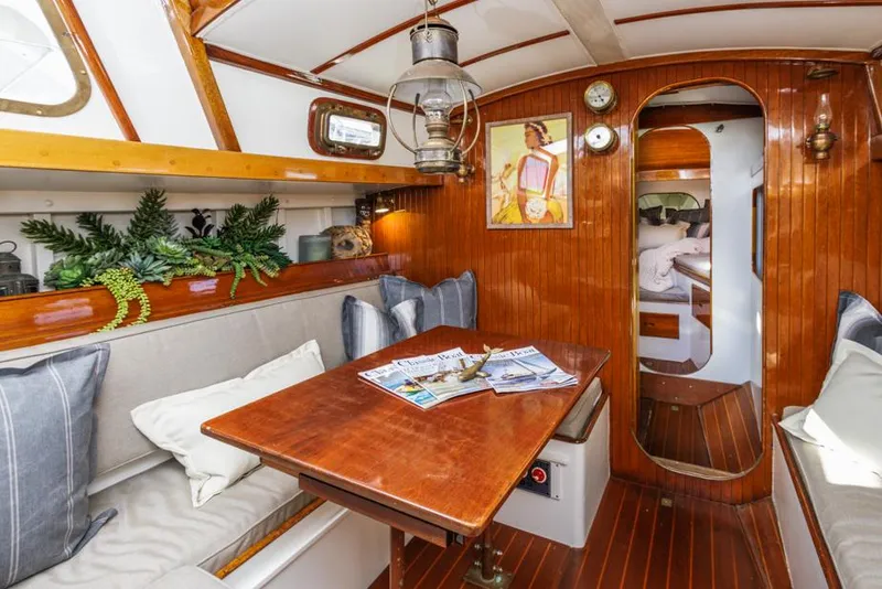 Slide: The Image of Interior of a 1961 Lapworth 40 sailboat with wooden paneling and cozy seating area. - 41