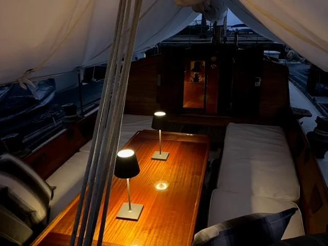 Slide: The Image of Interior of a 1961 Lapworth 40 sailboat with cozy seating and warm lighting. - 46