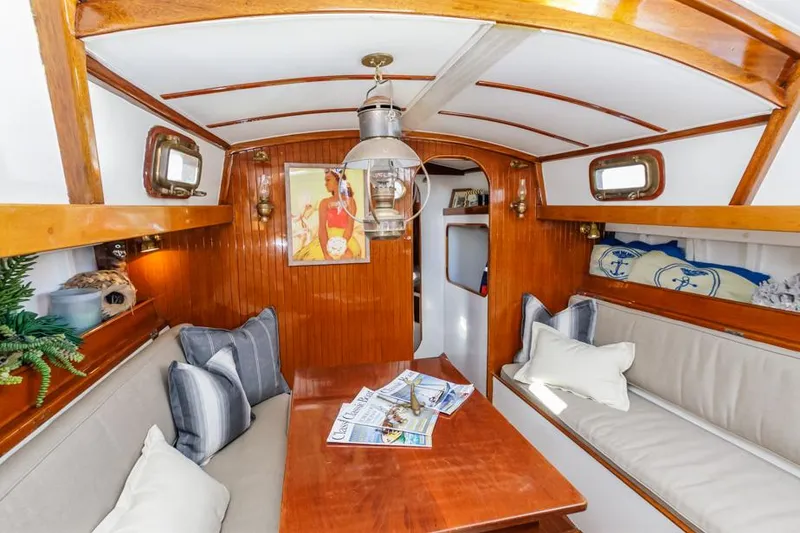Slide: The Image of Interior of a 1961 Lapworth 40 sailboat with cozy seating and wooden finishes. - 5