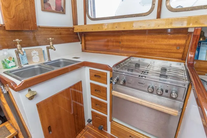 Slide: The Image of 1961 Lapworth 40 yacht kitchen with wooden cabinetry, dual sink, and stove. - 6