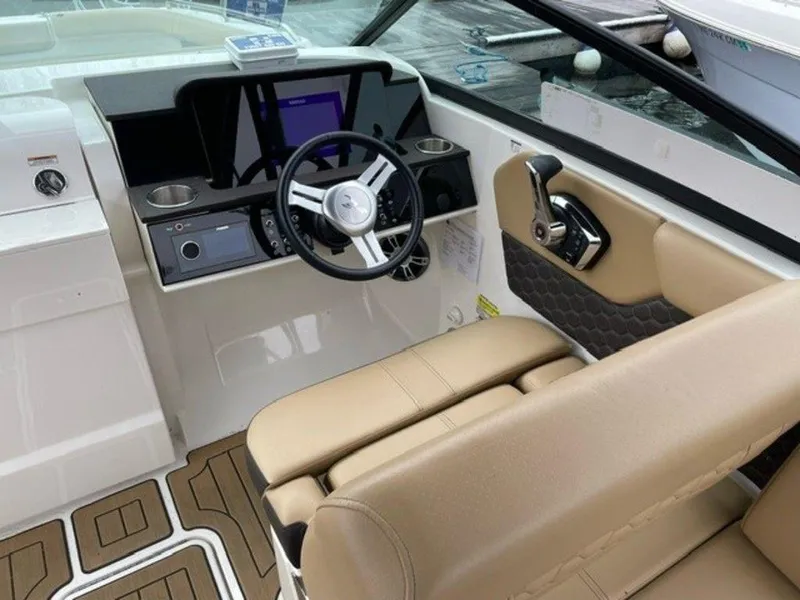 Slide: The Image of 2023 Sea Ray 250 SDX boat cockpit with modern steering wheel and beige seating. - 3