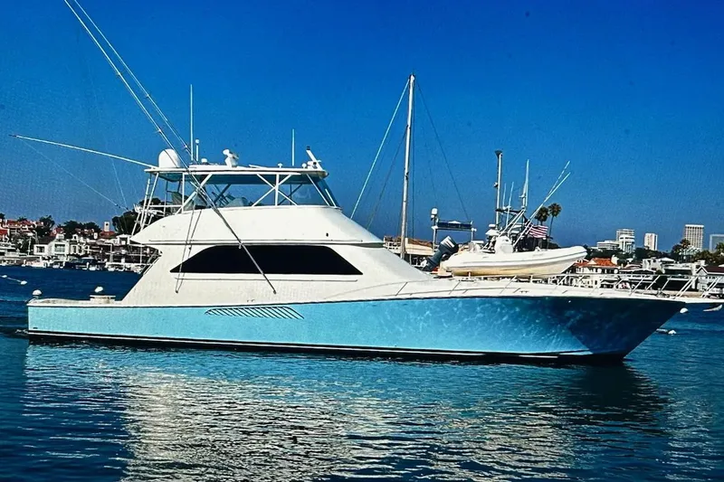 Slide: The Image of Viking 65 Convertible yacht, 2000 model, docked in a marina under clear blue skies. - 1
