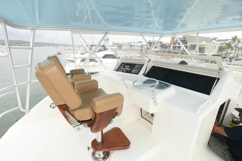 Slide: The Image of 2000 Viking 65 Convertible yacht helm station with leather seats and modern controls. - 12