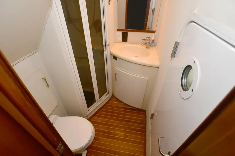 Slide: The Image of Compact bathroom in 2000 Viking 65 Convertible yacht with shower, sink, and toilet. - 22