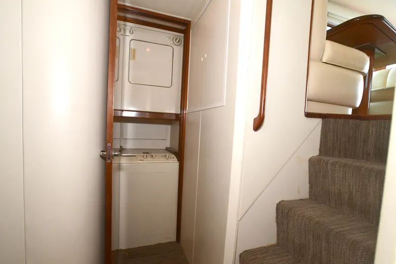 Slide: The Image of Laundry area with stacked washer and dryer in 2000 Viking 65 Convertible yacht. - 23