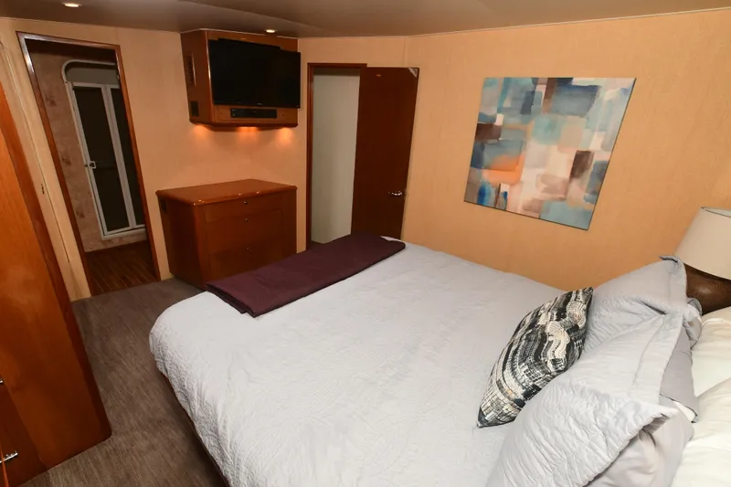 Slide: The Image of Bedroom interior of a 2000 Viking 65 Convertible yacht with modern decor. - 29