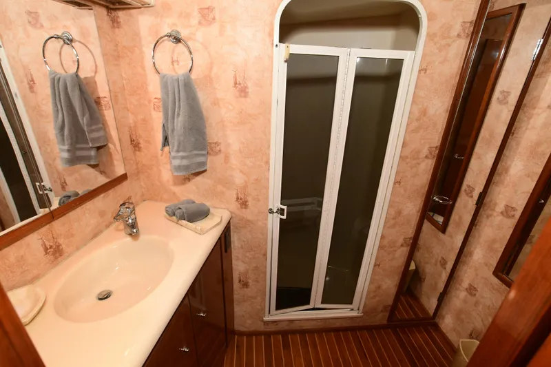 Slide: The Image of Bathroom interior of a 2000 Viking 65 Convertible yacht with sink and shower. - 30