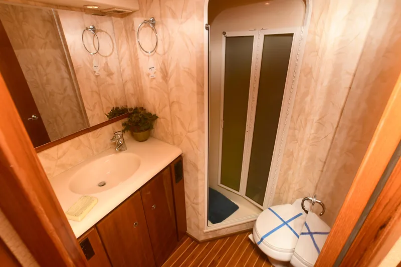 Slide: The Image of Bathroom interior of a 2000 Viking 65 Convertible yacht with sink, shower, and toilet. - 35