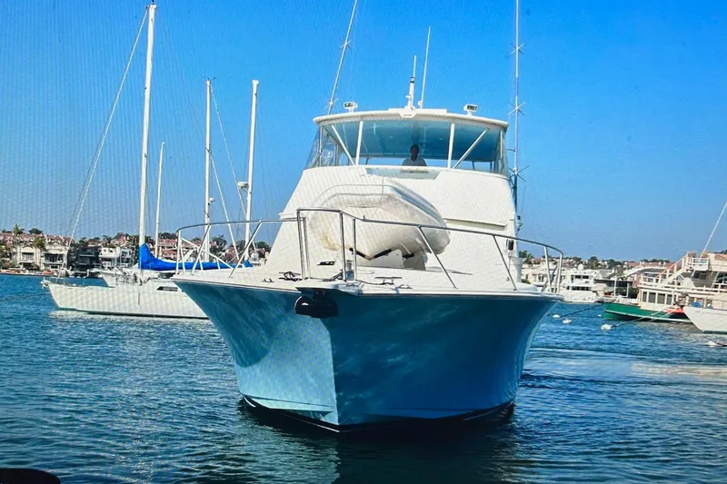 Slide: The Image of Viking 65 Convertible yacht, 2000 model, docked in a marina under clear blue skies. - 4