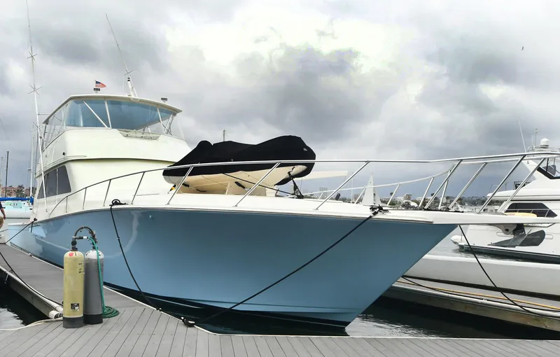 Slide: The Image of 2000 Viking 65 Convertible yacht docked at marina under cloudy sky. - 8