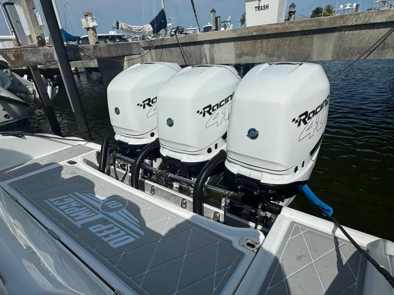 Slide: The Image of Deep Impact 36 Open 2003 boat with triple Racing outboard engines at a marina. - 24