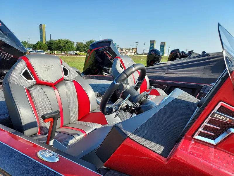 Slide: The Image of 2023 Ranger Z520R boat interior with red and gray seats and steering wheel. - 2