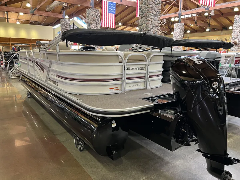 Slide: The Image of 2023 Ranger Reata 243C pontoon boat on display indoors. - 3