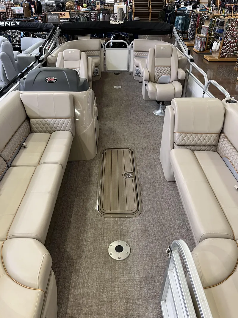 Slide: The Image of 2023 Ranger Reata 243C pontoon boat interior with beige seating and spacious layout. - 4