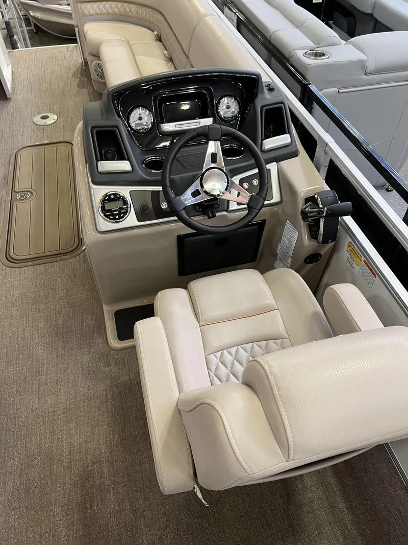 Slide: The Image of 2023 Ranger Reata 243C boat interior with steering console and beige seating. - 6