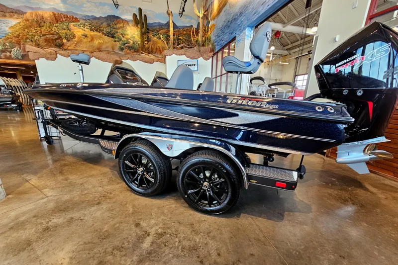Slide: The Image of 2023 Triton 20 TRX bass boat on showroom floor with dual-axle trailer. - 2