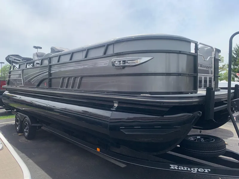 Slide: The Image of 2023 Ranger 2500LS pontoon boat on trailer, sleek design, black and gray finish. - 0
