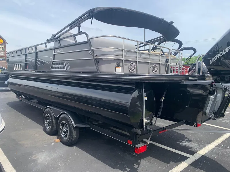 Slide: The Image of 2023 Ranger 2500LS pontoon boat on trailer, black exterior, parked outdoors. - 1