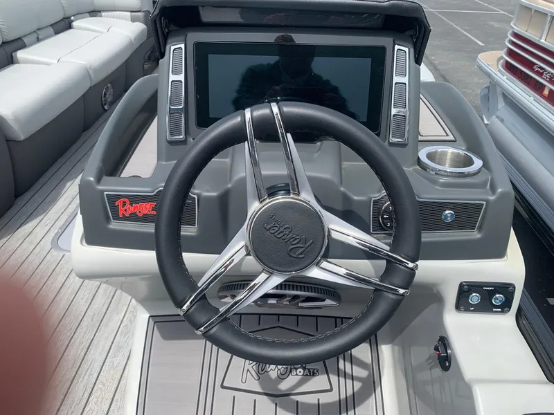 Slide: The Image of Steering wheel and dashboard of 2023 Ranger 2500LS boat, featuring modern controls and display. - 7