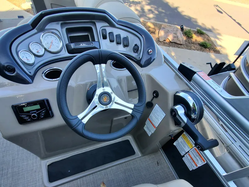 Slide: The Image of 2023 Sun Tracker Party Barge 18 DLX steering console with gauges and controls. - 2