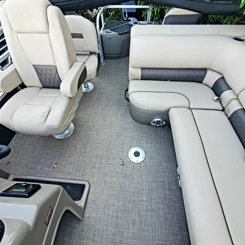 Slide: The Image of 2023 Sun Tracker Party Barge 18 DLX interior with beige seating and spacious layout. - 3