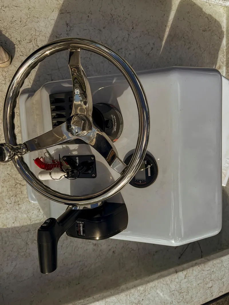Slide: The Image of Steering console of a 2022 Bossman 17 Flats Boat with chrome wheel and controls. - 12