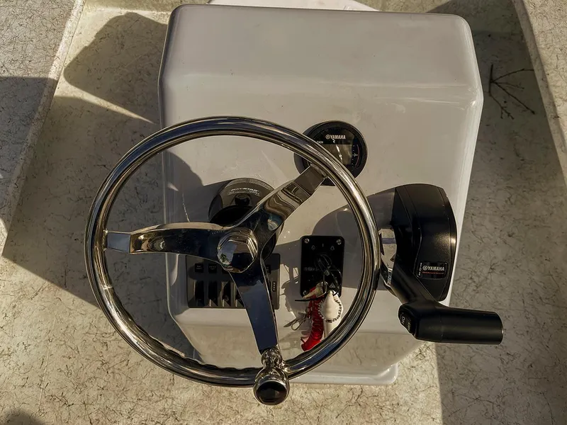 Slide: The Image of Steering console of a 2022 Bossman 17 Flats Boat with chrome wheel and controls. - 13