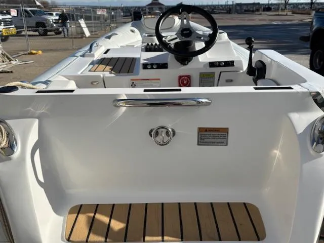 Slide: The Image of 2024 AB Inflatables ABJET 290 boat interior with steering wheel and wooden deck. - 2