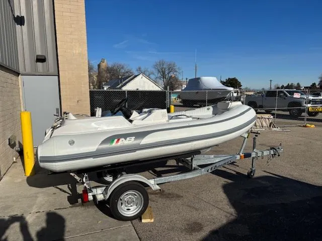 Slide: The Image of 2024 AB Inflatables ABJET 290 on trailer, parked outdoors under clear blue sky. - 5