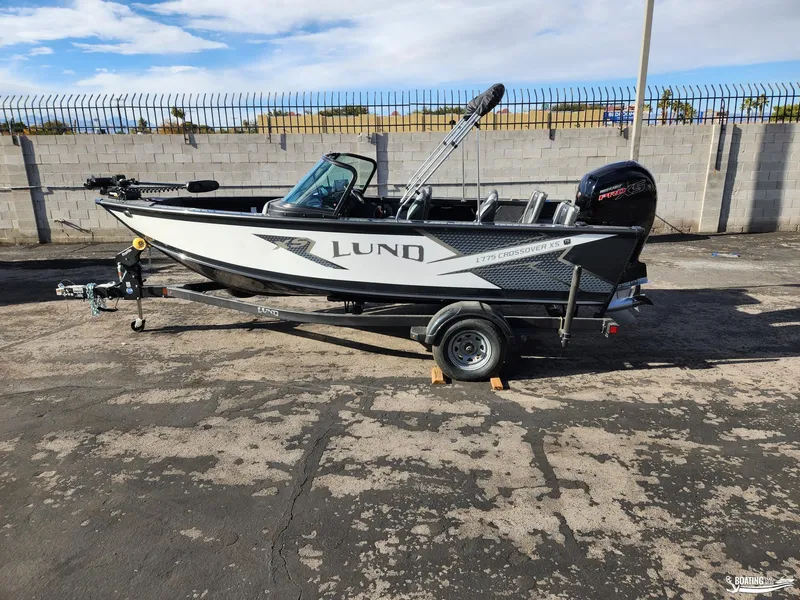Slide: The Image of 2023 Lund 1775 Crossover XS boat on trailer, parked outdoors. - 0