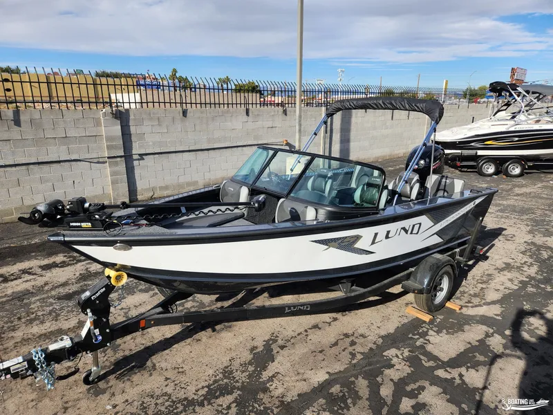 Slide: The Image of 2023 Lund 1775 Crossover XS boat on trailer, parked outdoors. - 2