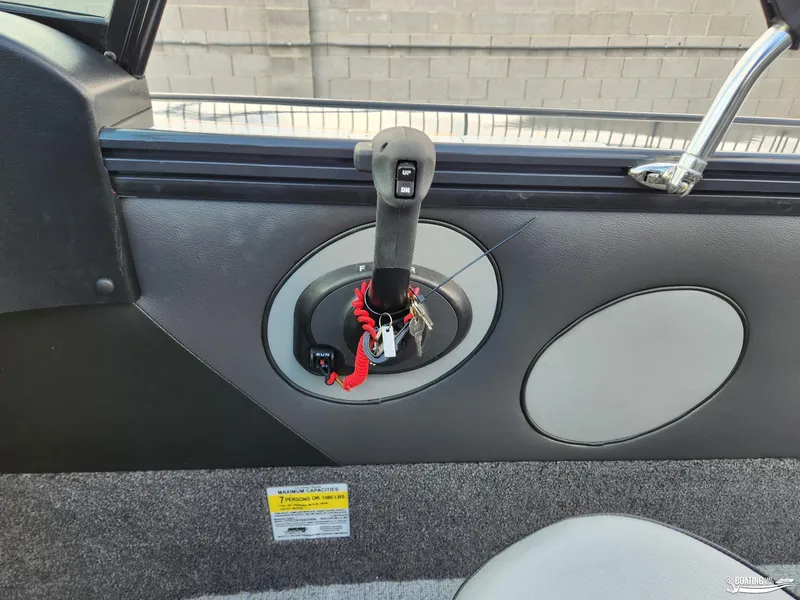 Slide: The Image of 2023 Lund 1775 Crossover XS boat interior with control lever and safety lanyard. - 8