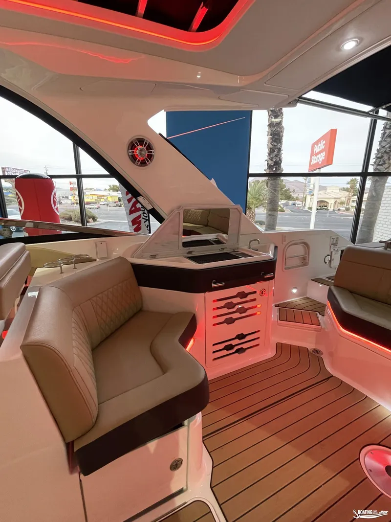 Slide: The Image of 2023 Sea Ray 310 SLX boat interior with luxurious seating and ambient lighting. - 12