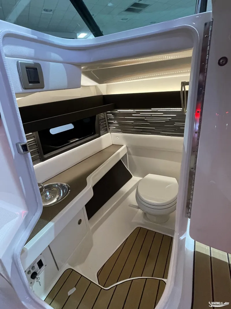 Slide: The Image of 2023 Sea Ray 310 SLX boat interior with modern bathroom and sleek design. - 13