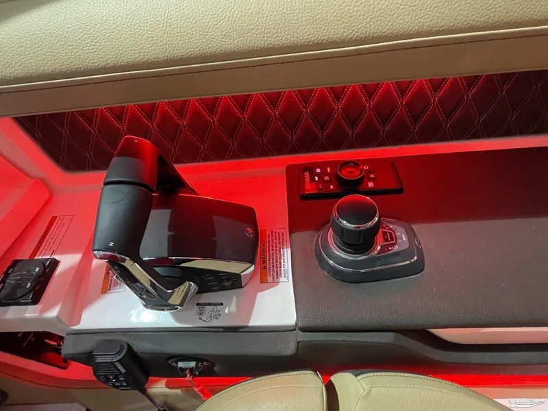 Slide: The Image of 2023 Sea Ray 310 SLX boat control panel with red ambient lighting. - 19