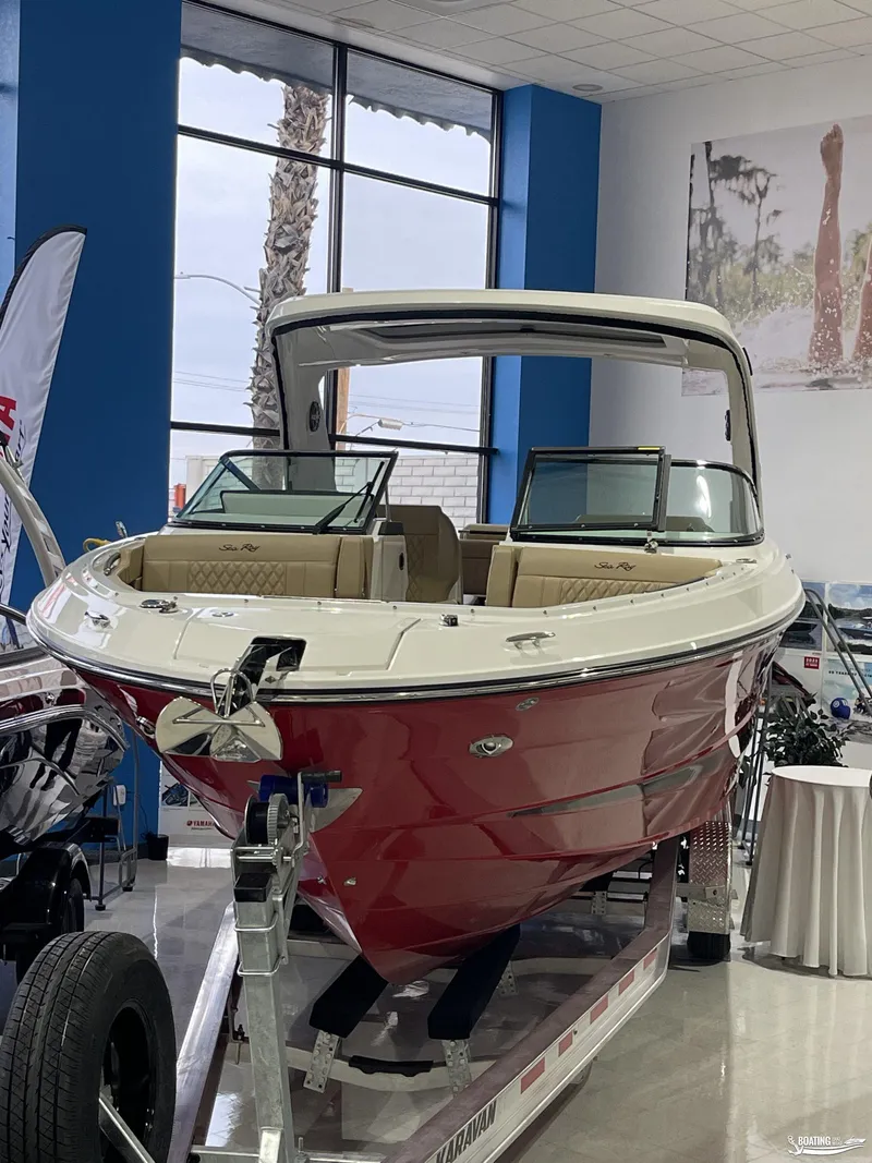Slide: The Image of 2023 Sea Ray 310 SLX boat with red hull displayed indoors. - 2