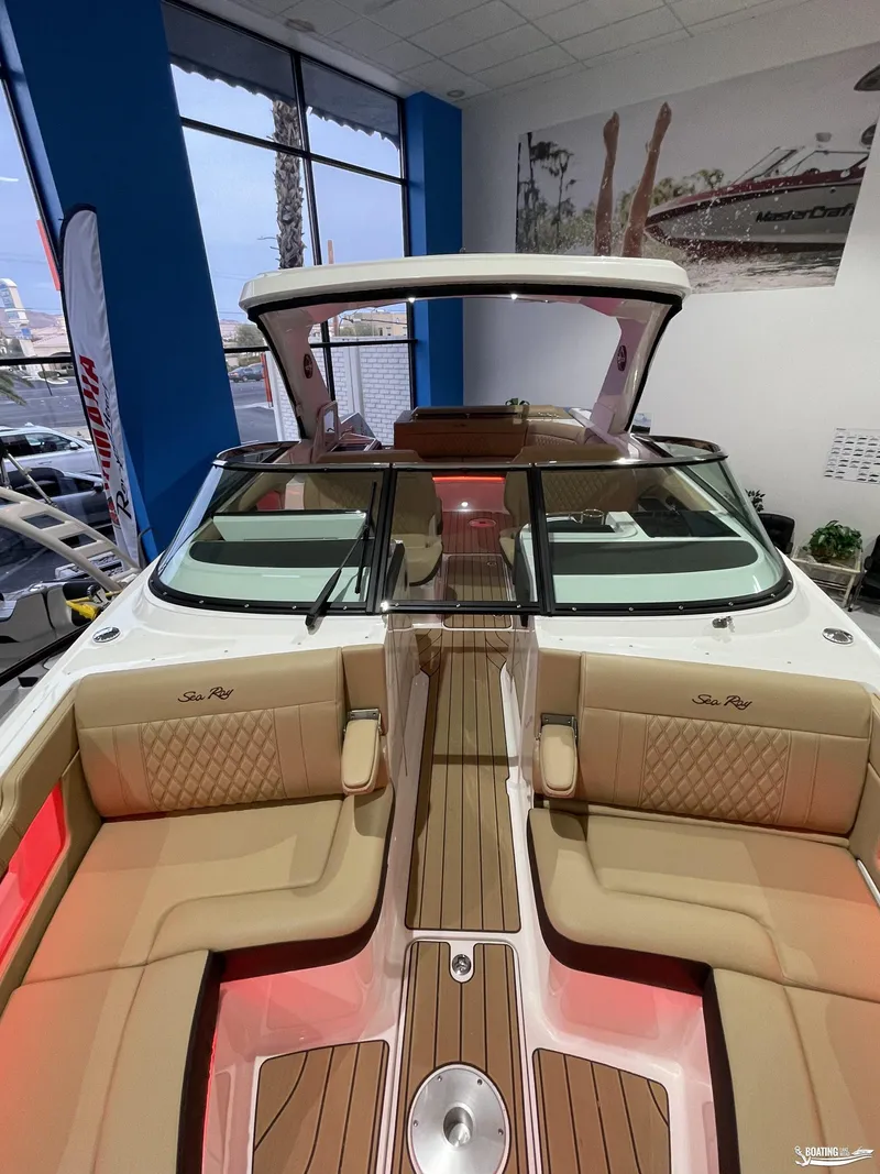 Slide: The Image of 2023 Sea Ray 310 SLX luxury boat interior with tan seating and wood accents. - 22