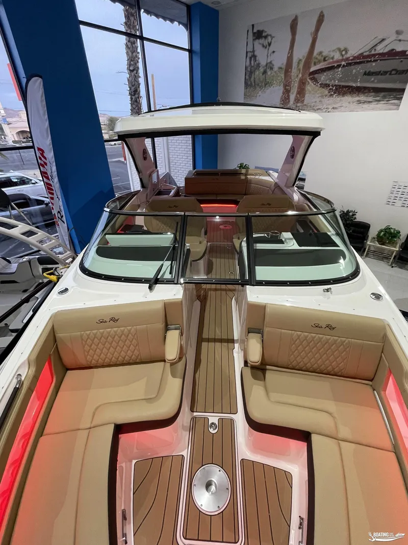 Slide: The Image of 2023 Sea Ray 310 SLX luxury boat interior with tan seating and wood accents. - 24