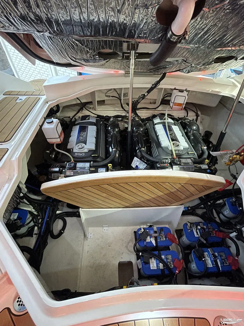 Slide: The Image of 2023 Sea Ray 310 SLX engine compartment with dual engines and batteries. - 28