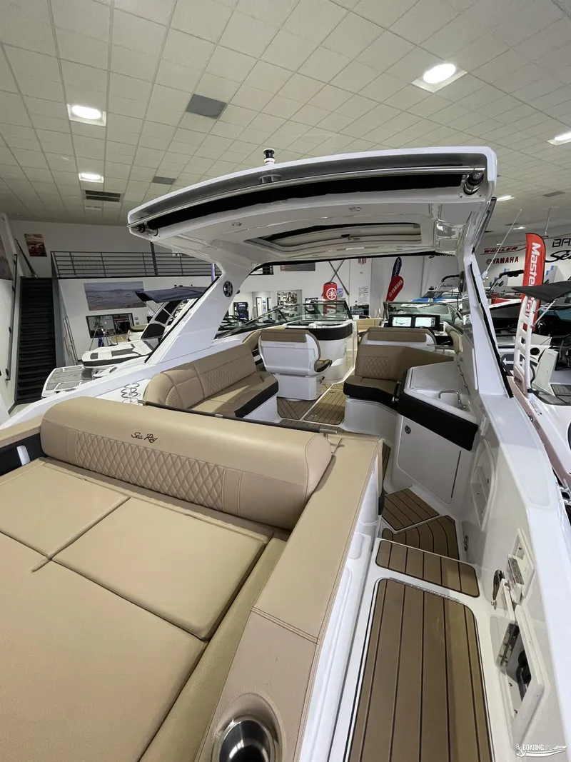 Slide: The Image of 2023 Sea Ray 310 SLX luxury boat interior with beige seating in showroom. - 4