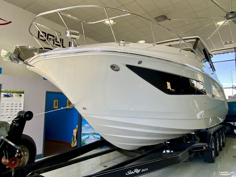 Slide: The Image of 2025 Sea Ray 320 Sundancer boat displayed indoors on a trailer. - 3