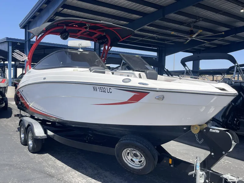 Slide: The Image of 2018 Yamaha Boats 242 X E Series on trailer under a metal canopy. - 1