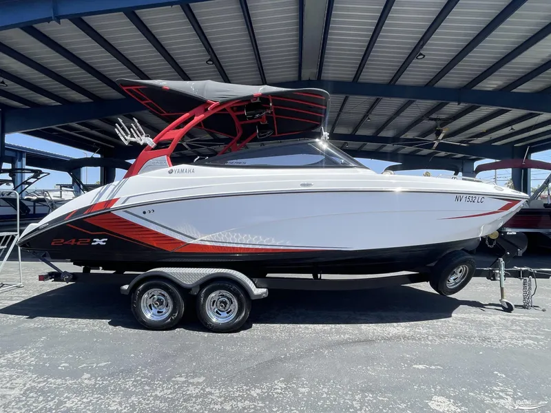 Slide: The Image of 2018 Yamaha Boats 242 X E Series on trailer under a metal canopy. - 2