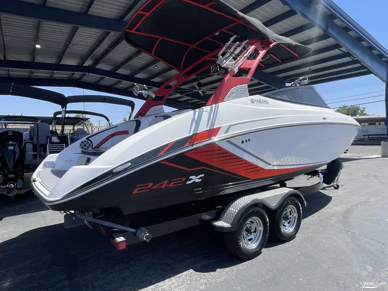 Slide: The Image of 2018 Yamaha Boats 242 X E Series on trailer under a metal canopy. - 3