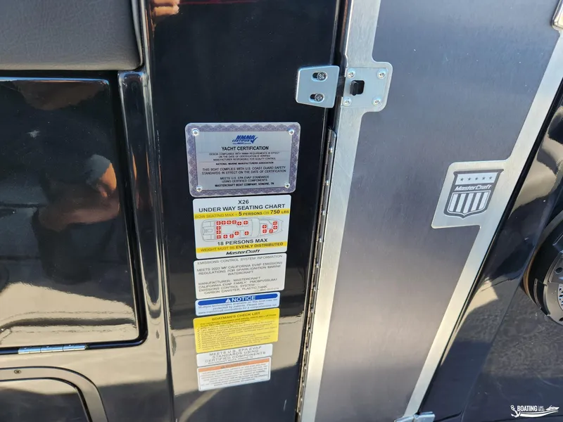 Slide: The Image of 2023 MasterCraft X26 yacht certification and seating capacity labels on black panel. - 11