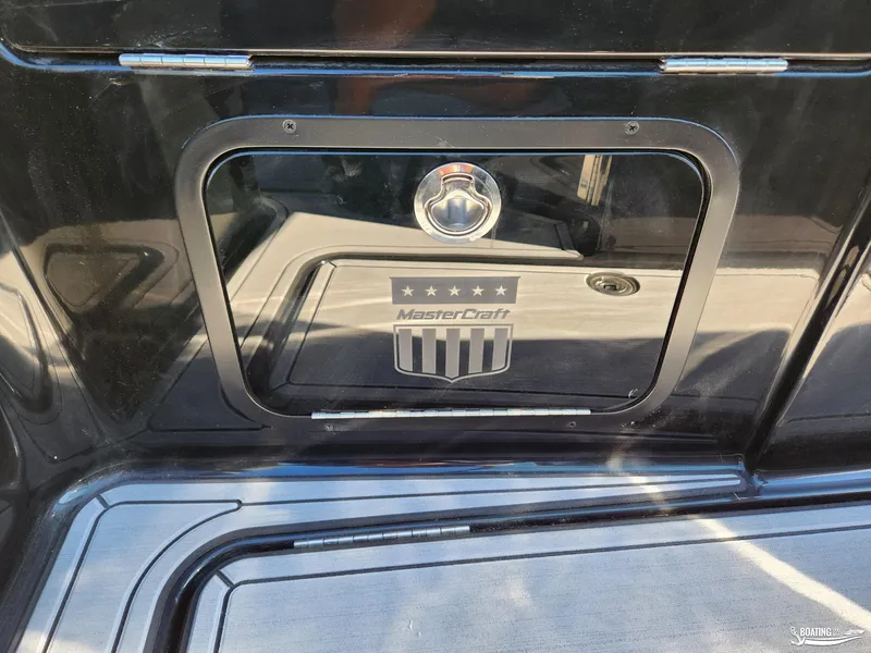 Slide: The Image of 2023 MasterCraft X26 boat storage compartment with logo and sleek design. - 12