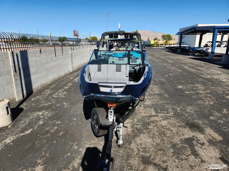 Slide: The Image of 2023 MasterCraft X26 boat on trailer in outdoor lot. - 2