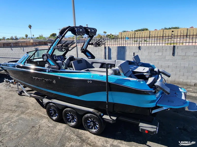Slide: The Image of 2023 MasterCraft X26 boat on trailer, sleek design, vibrant blue and black color scheme. - 20